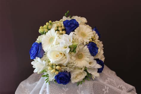 white-hydrangea,-white-gerbera-daisies,-blue-roses,-white-roses,-white-hypericum-berries