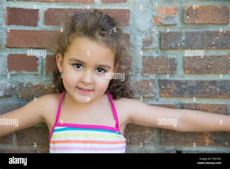 Portrait Of Little Girl Leaning Against Brick Wall Stock Photo Alamy