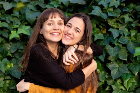 Outdoor Portrait Of Two Happy Sisters In A Park Stock Photo Image Of
