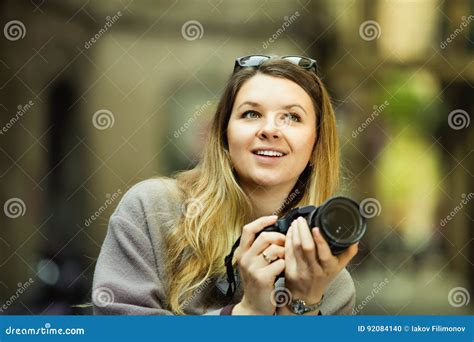 Girl Holding Camera In Hands And Photographing In The City Stock Photo