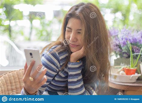 Happy Young Asian Woman Taking Selfie Or Using Mobile