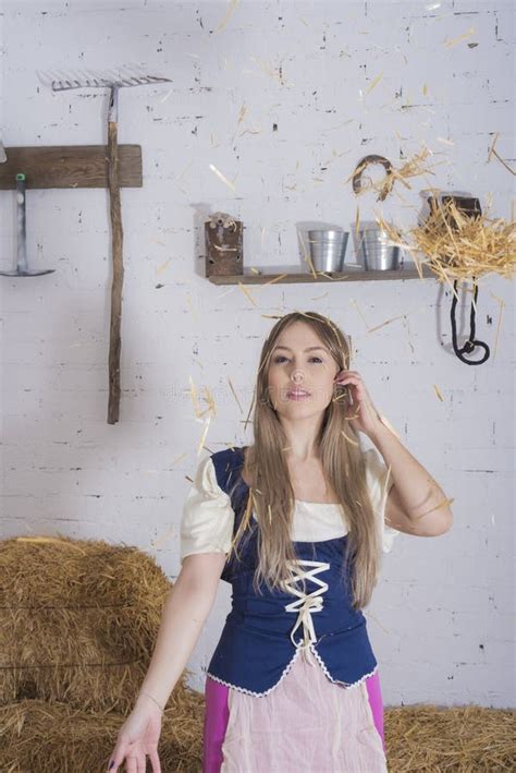 Beautiful Young Woman Dressed In Farmer Outfit In Barn With Hay Stock