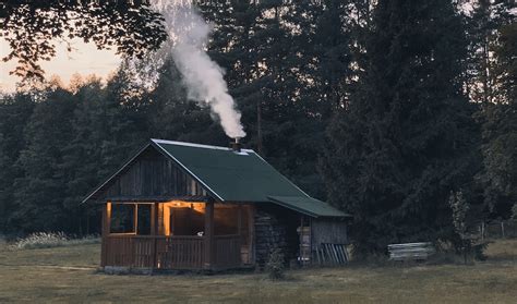 Cabin With Smoke Coming Out Of Chimney Near Trees Photo Free Nature