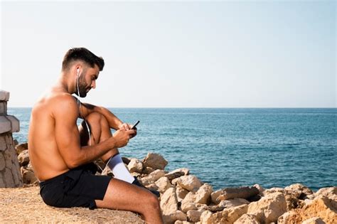 Hombre Guapo Sentado En La Playa Foto Gratis