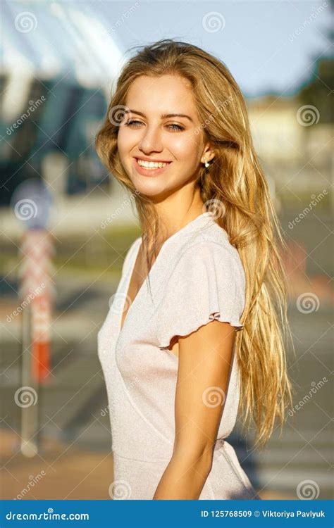 Positive Blonde Woman With Long Hair Posing At The Background Of Stock