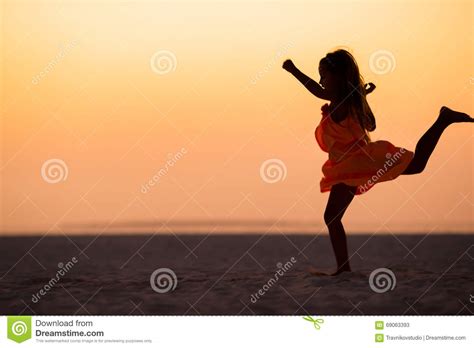 Silhouette Of Sporty Little Girl On White Beach At Sunset Stock Image
