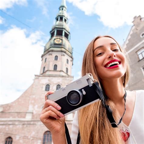 Young Female Photographer Smiling As She Snaps A Picture In Riga Old