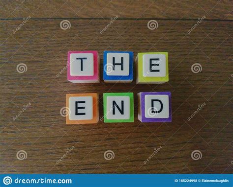 The End Message In Colorful Letters On Wood Background Stock Photo