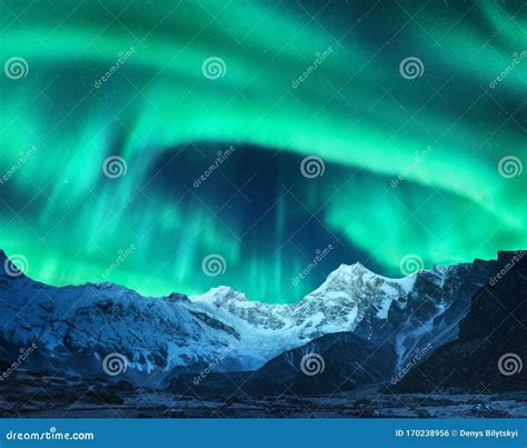 Aurora Borealis Above Snow Covered Mountain Range In Europe Stock Photo