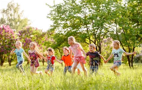 Un Grupo De Niños Felices De Niños Y Niñas Corren En El Parque En La
