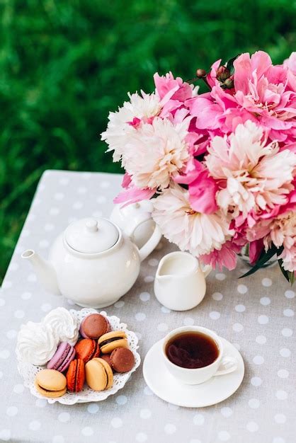 A Vase With Peonies A Teapot And A Cup Of Tea On The Table Premium Photo