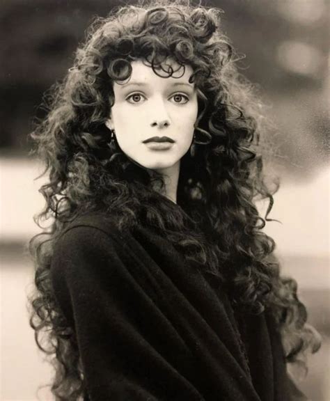 An Old Photo Of A Woman With Curly Hair