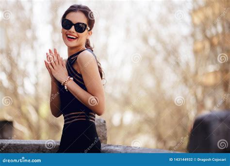 förtjusande elegant brunett i sexig svart klänning solglasögon hårhästsvans och härligt