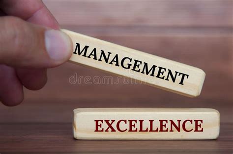 Hand Holding Management Excellence Text On Wooden Blocks Management