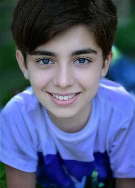 A Close Up Of A Person Wearing A White Shirt And Smiling At The Camera