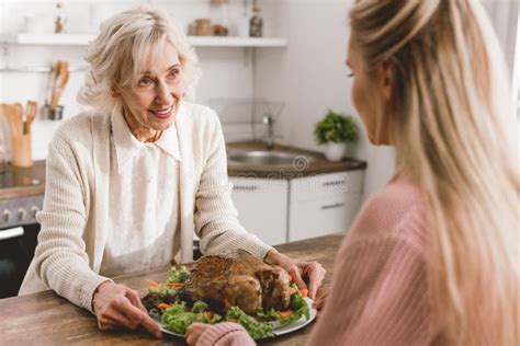 Mother And Daughter Holding Plate With Turkey In Thanksgiving Day Stock