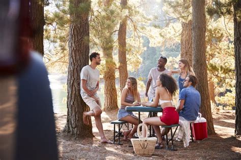 Group Of Young Adult Friends Hanging Out By A Lake Stock Photo Image