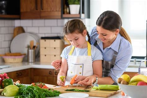 Mother Teaching Child To Cook And Help In The Kitchen Stock Image