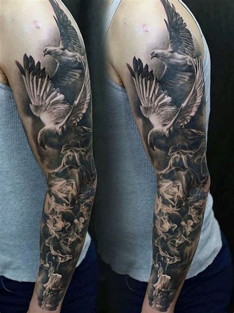 A Man With A Tattoo On His Arm And Shoulder Is Holding A Bird In The Air