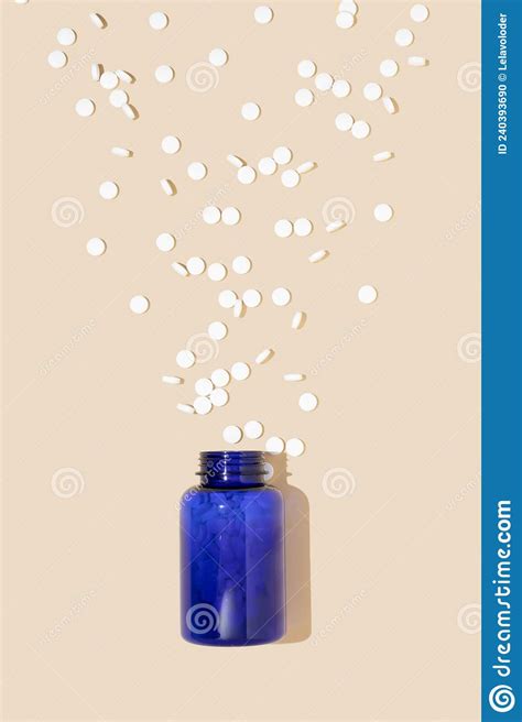 blue medication bottle and white pills spilled on bright pastel background medication and