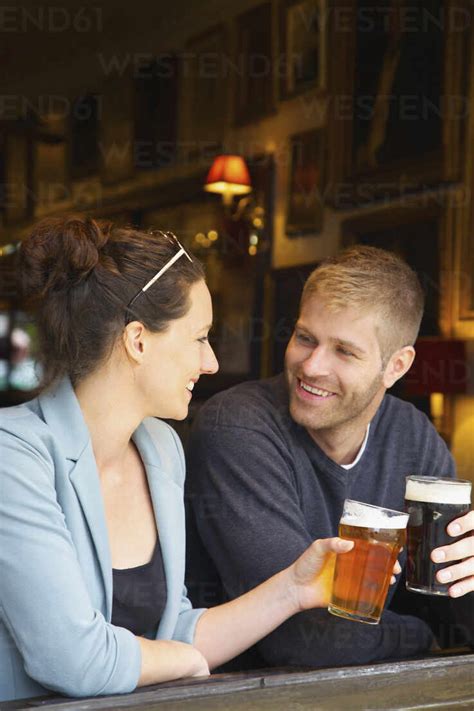 Happy Couple Drinking Beer In Pub Stock Photo