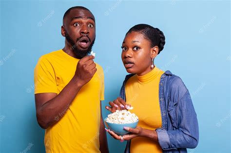 Free Photo Couple Watching Horror Movie On Television And Eating Popcorn Being Scared And
