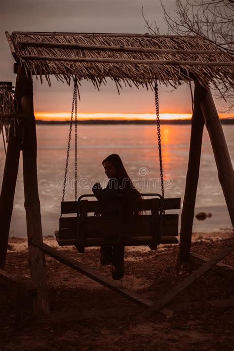 Woman Enjoying Time Relaxing By The Beautiful Lake At Sunrise Stock