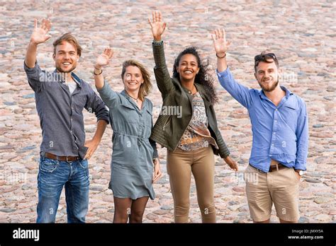 Group Of Young Friends Waving Their Hands As A Gesture Of Saying