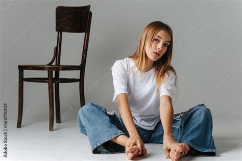 Stylish Eccentric Teenage Girl Sitting On The Floor Holding Her Bare Feet Foto De Stock Adobe