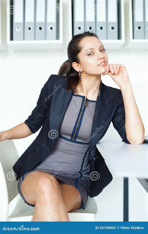 Young Contemplative Business Woman Sitting At The Desk Stock Photo