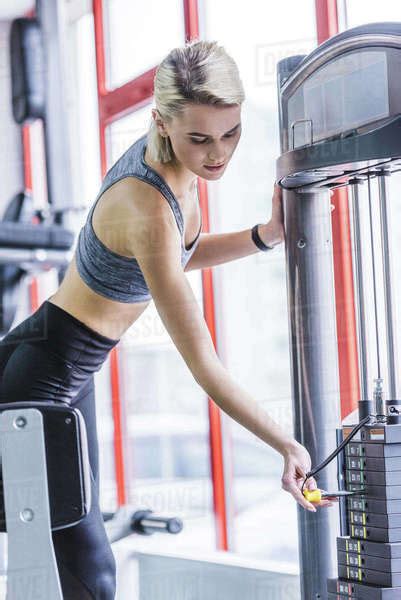 Sportive Young Woman Adding Weight On Gym Machine Stock Photo Dissolve