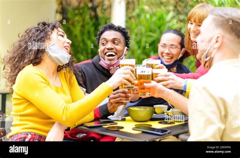 Happy Group Of Multiracial Friends With Face Mask Drinking And Toasting
