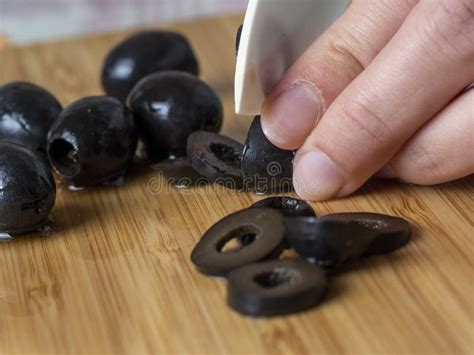 Black Olives Are Cut Into Pieces With A Sharp Knife Stock Photo Image