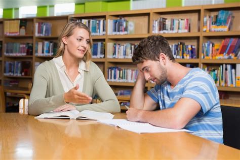 Premium Photo Student Getting Help From Tutor In Library