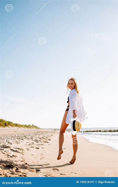 Beautiful Luxury Slim Girl In A Black Bikini And White Shirt On The Beach The Ocean Tanned Body