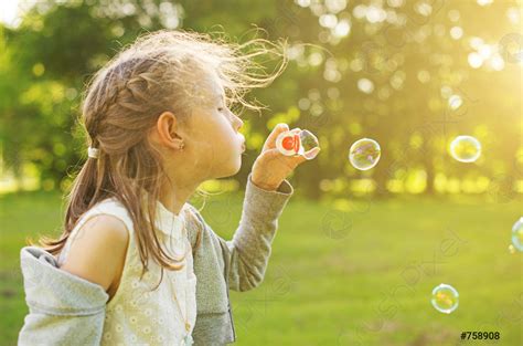 Little Girl Blowing Soap Bubbles In The Park Stock Photo 758908