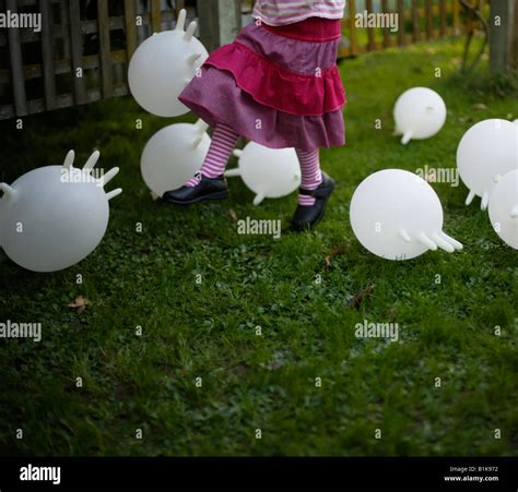 Inflated Latex Rubber Gloves Become Makeshift Balloons Kicked Around The Garden By A Four Year