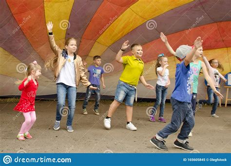 Children Have Fun Dancing Under A Multi Colored Tension Dome At A City