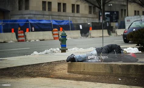 A Homeless Man Sleeps On A Steam Grate Near The Department Of News