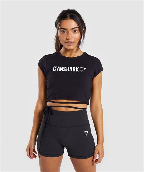 The Gymshark Crop Top Is Black With White Print On It And Has Short Shorts
