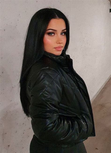 A Woman With Long Black Hair Wearing A Black Leather Jacket And Posing