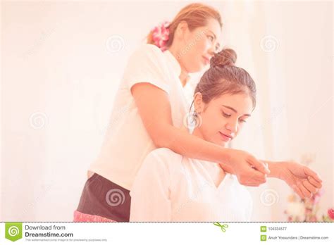 Thai Masseuse Is Massaging Woman Shoulder In Thai Massage Spa Position