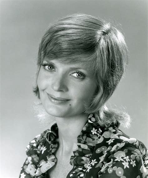 An Old Photo Of A Woman With Blonde Hair And Floral Shirt Smiling At