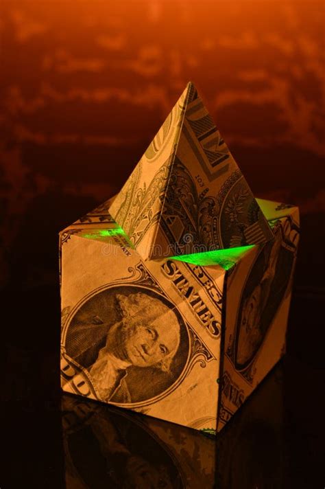 Dollar Bill Pyramid Resting Atop A Cube Made Of Dollar Bills Stock