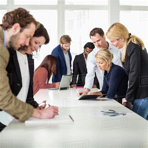 Group Of Business People Working Together At Desk In Office Stock Photo Dissolve