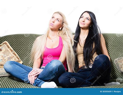 Portrait Of Two Pretty Young Girlfriends Or Sisters Sitting Together