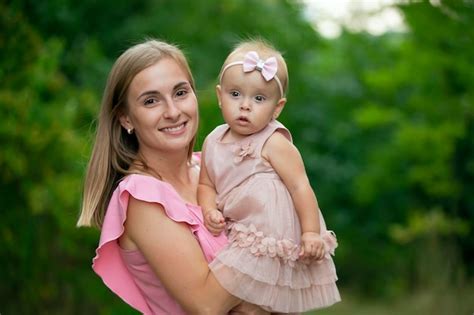 Premium Photo Happy Woman Holds Oneyearold Daughter In Her Arms