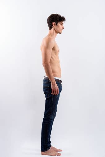 Full Body Shot Of Profile View Of Young Handsome Man Standing Shirtless