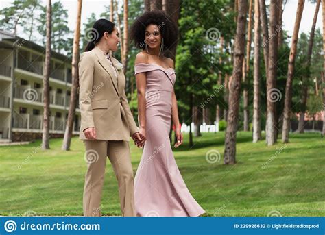 sonriente pareja de lesbianas interraciales en vestido foto de archivo imagen de género