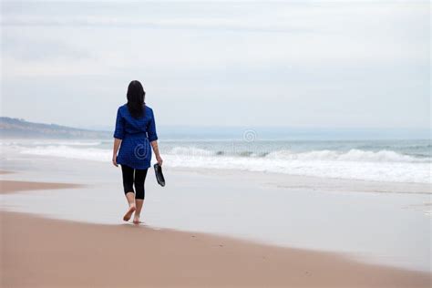 Young Woman Walking Away Alone In A Deserted Beach Stock Image Image